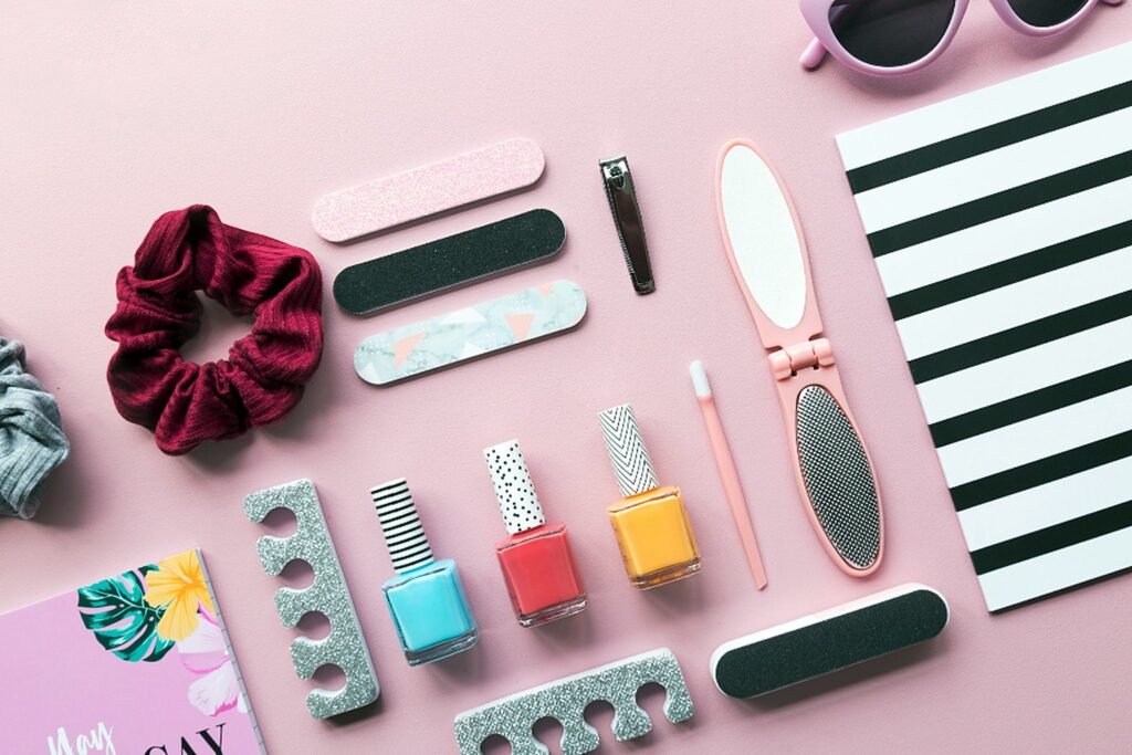 Nail polish, files and manicure tools on a pink background